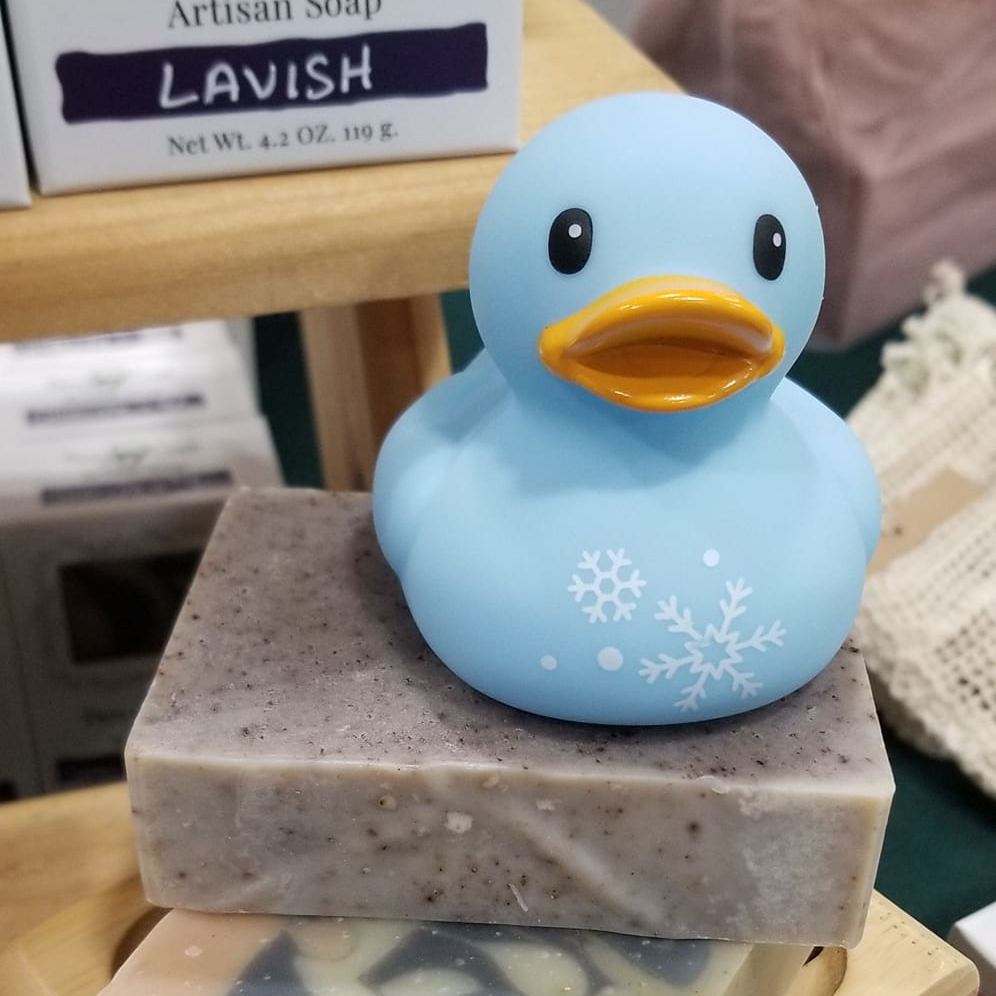 A blue rubber duck sitting on a bar of peppermint lavender soap colored with alkanet powder
