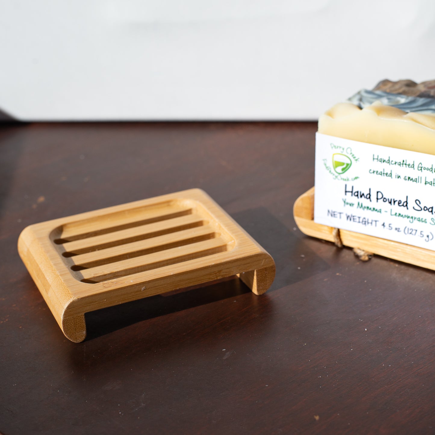 a bamboo soap dish with soap bars in the background